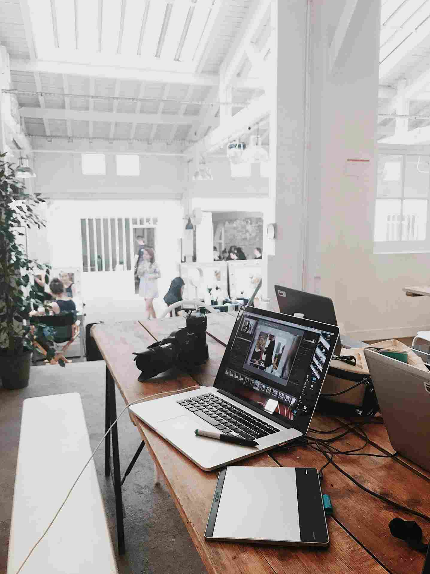 Creative workspace with laptop editing photos, camera, and graphic tablet at the best digital marketing company in Dehradun