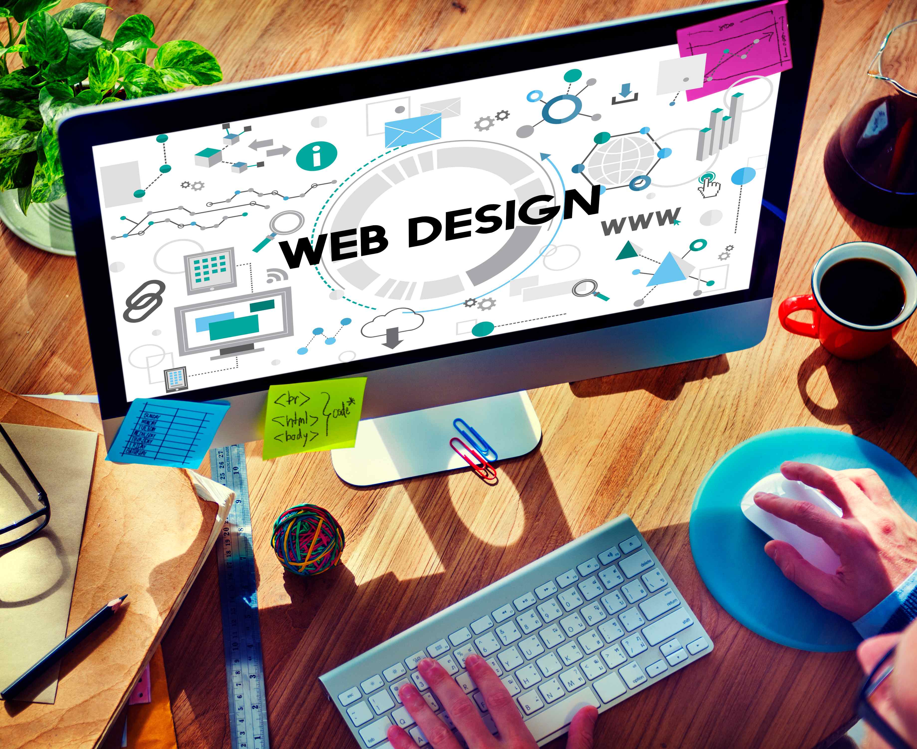 Web designing company workspace with computer screen showing web design graphics