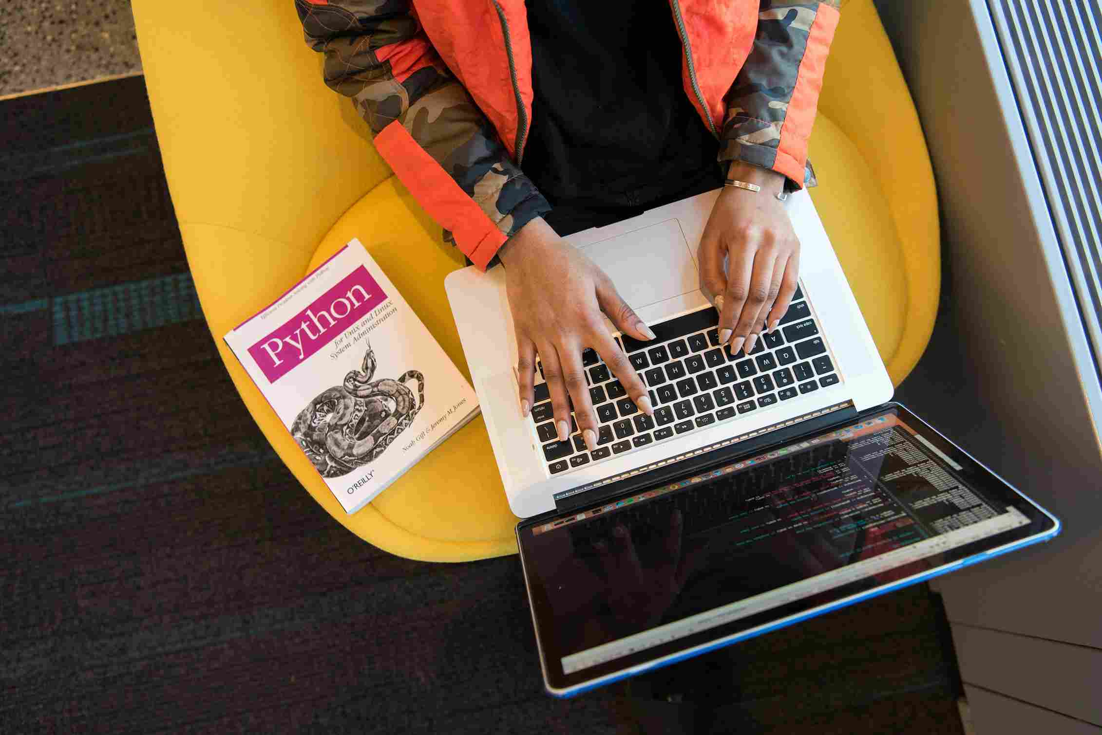 A developer writing Python code on a laptop at a website development agency in Dehradun